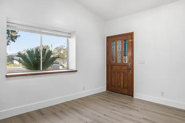 an empty room with wooden floor and window