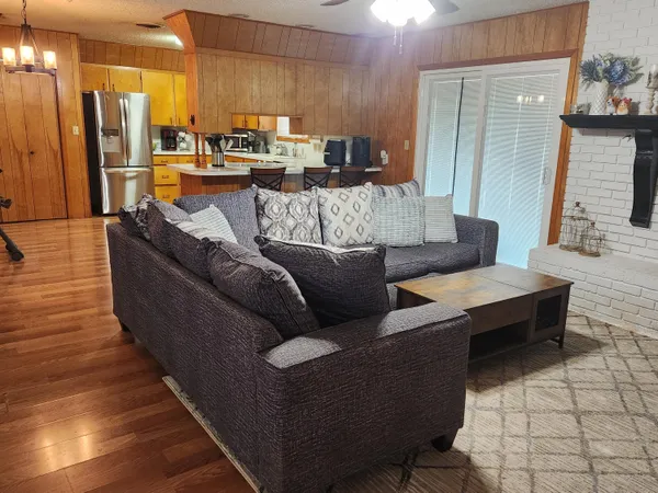 a living room with furniture wooden floor and a large window