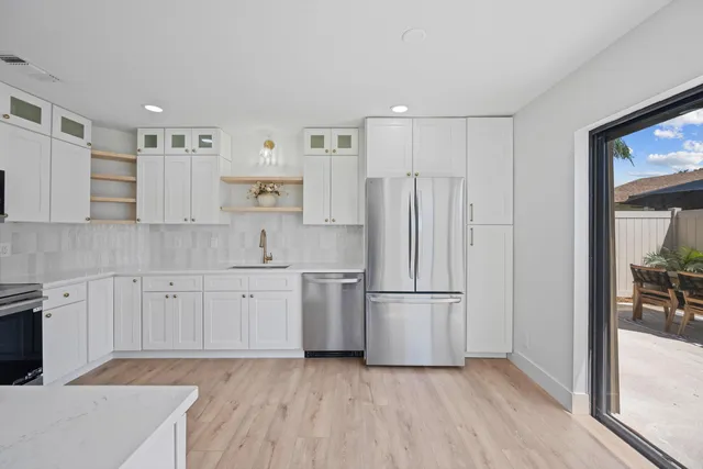 a kitchen with cabinets stainless steel appliances and wooden floor