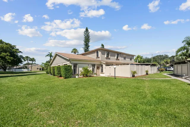 a view of a house with a big yard and potted plants