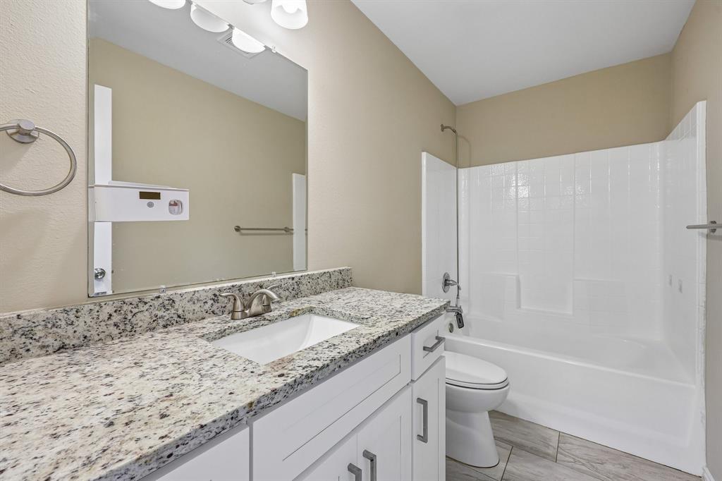 433 Whitney Court Rio Vista, TX 76093 - Photo 25 of 27 a bathroom with a granite countertop sink toilet and shower