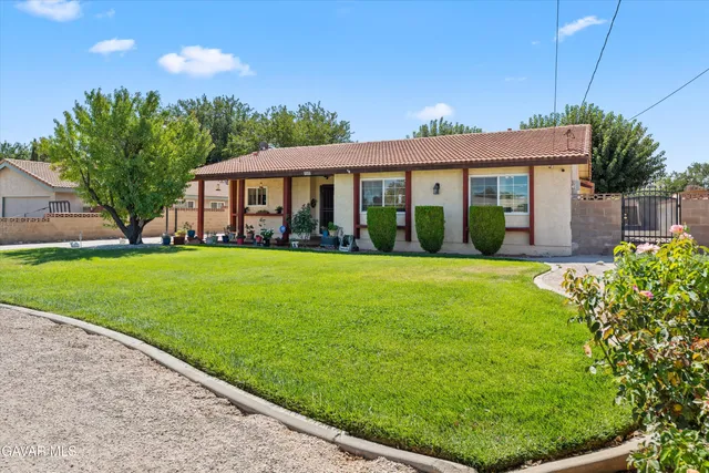 a view of a house with a big yard and potted plants