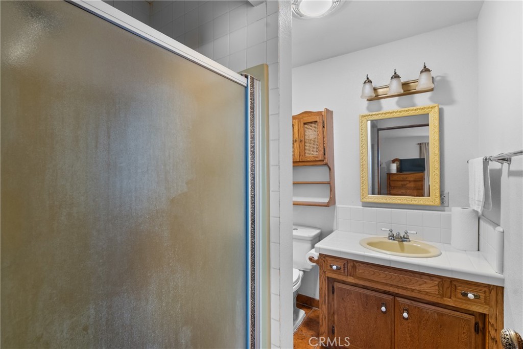 6650 Toro Creek Road Atascadero, CA 93422 - Photo 16 of 28 a bathroom with a granite countertop sink and a mirror