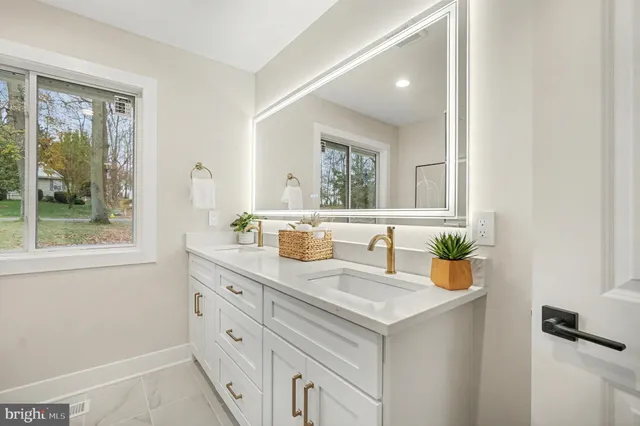 a bathroom with a granite countertop sink mirror vanity and toilet