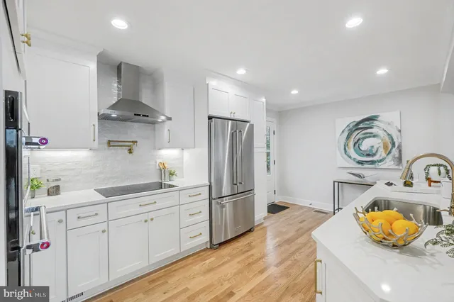 a kitchen with white cabinets and appliances