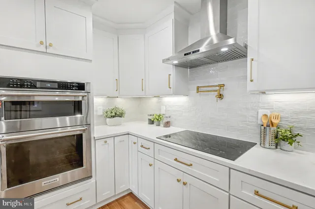 a kitchen with a sink a stove cabinets and wooden floor