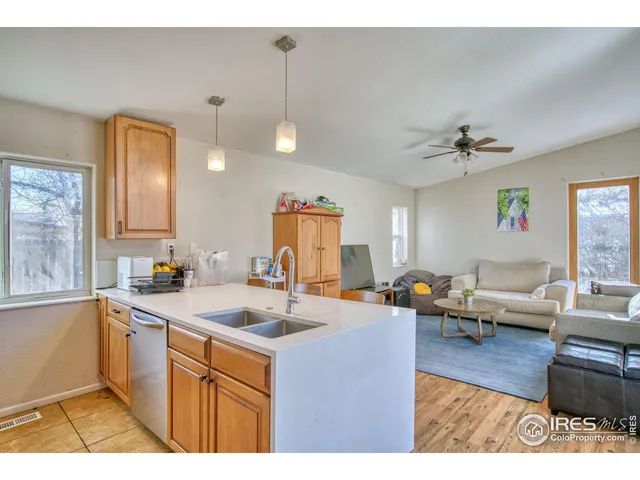 a kitchen with a sink dishwasher a stove and a dining table with wooden floor