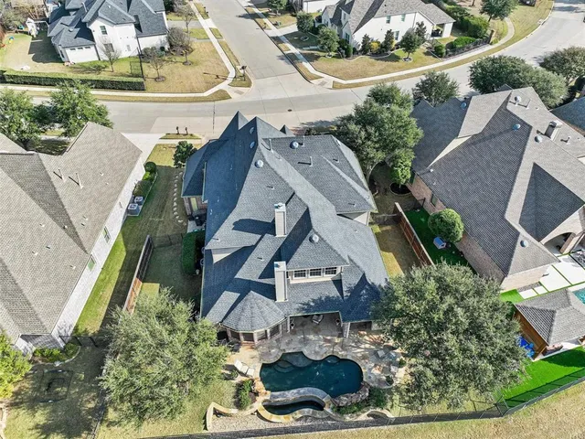 an aerial view of a house with a yard and lake view