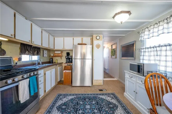 a kitchen with stainless steel appliances granite countertop a refrigerator a stove a sink and a microwave