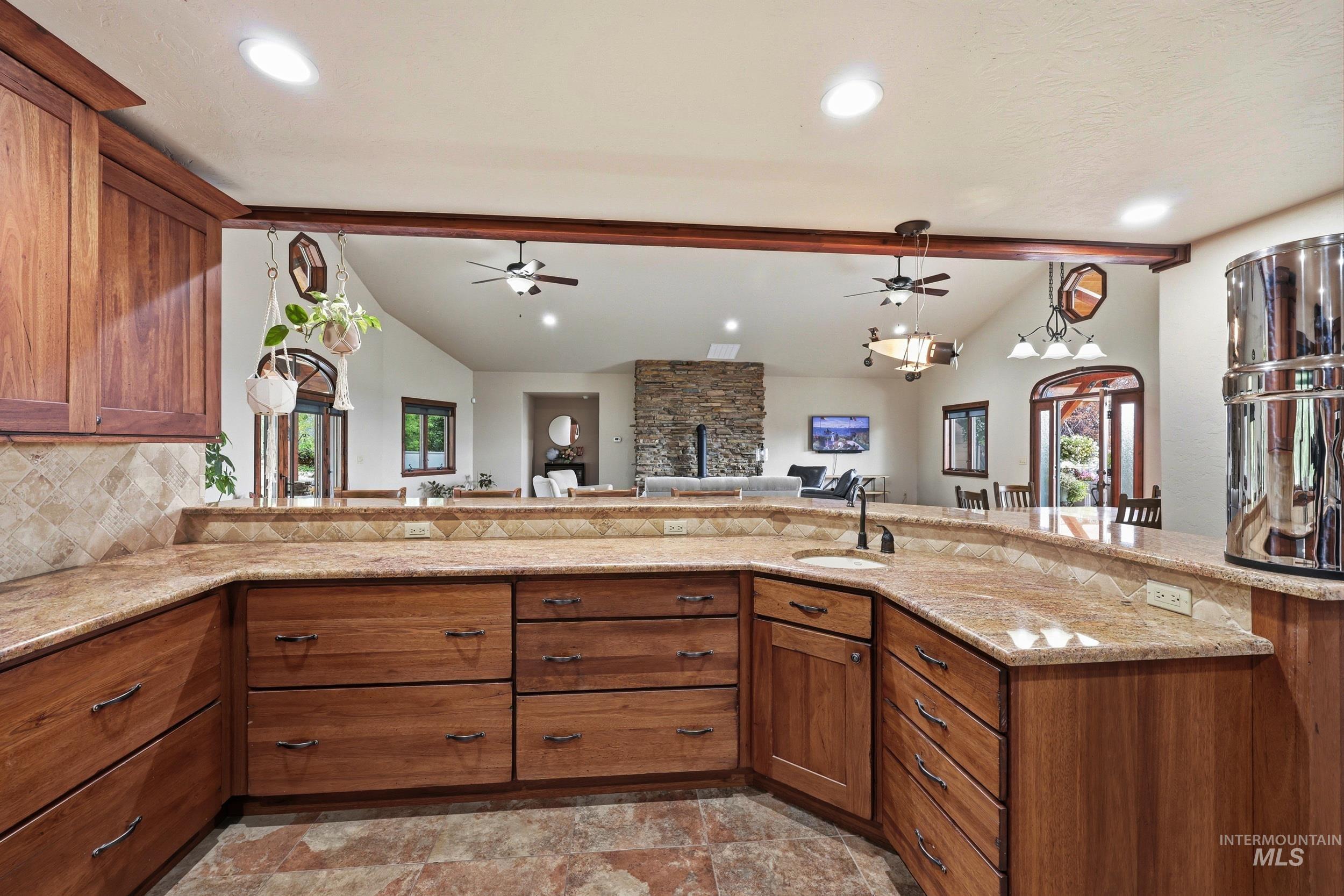 339 Airport Road Weiser, ID 83672 - Photo 13 of 49 Kitchen featuring wood-finish cabinetry, light-toned countertops, and a tiled backsplash