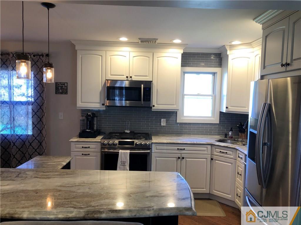 13 Phillips Road Edison, NJ 08817 - Photo 7 of 25 a kitchen with kitchen island granite countertop a sink stainless steel appliances and cabinets