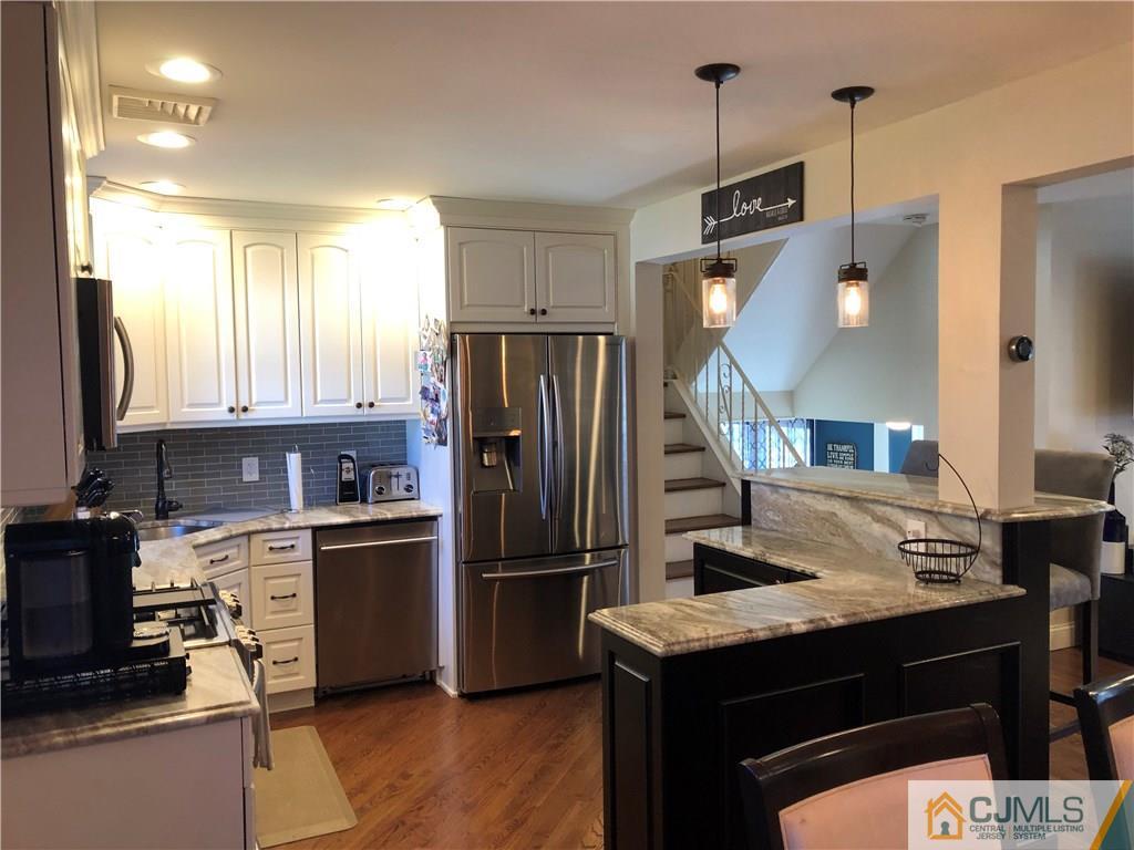 13 Phillips Road Edison, NJ 08817 - Photo 8 of 25 a kitchen with a refrigerator a sink dishwasher and a stove with wooden floor