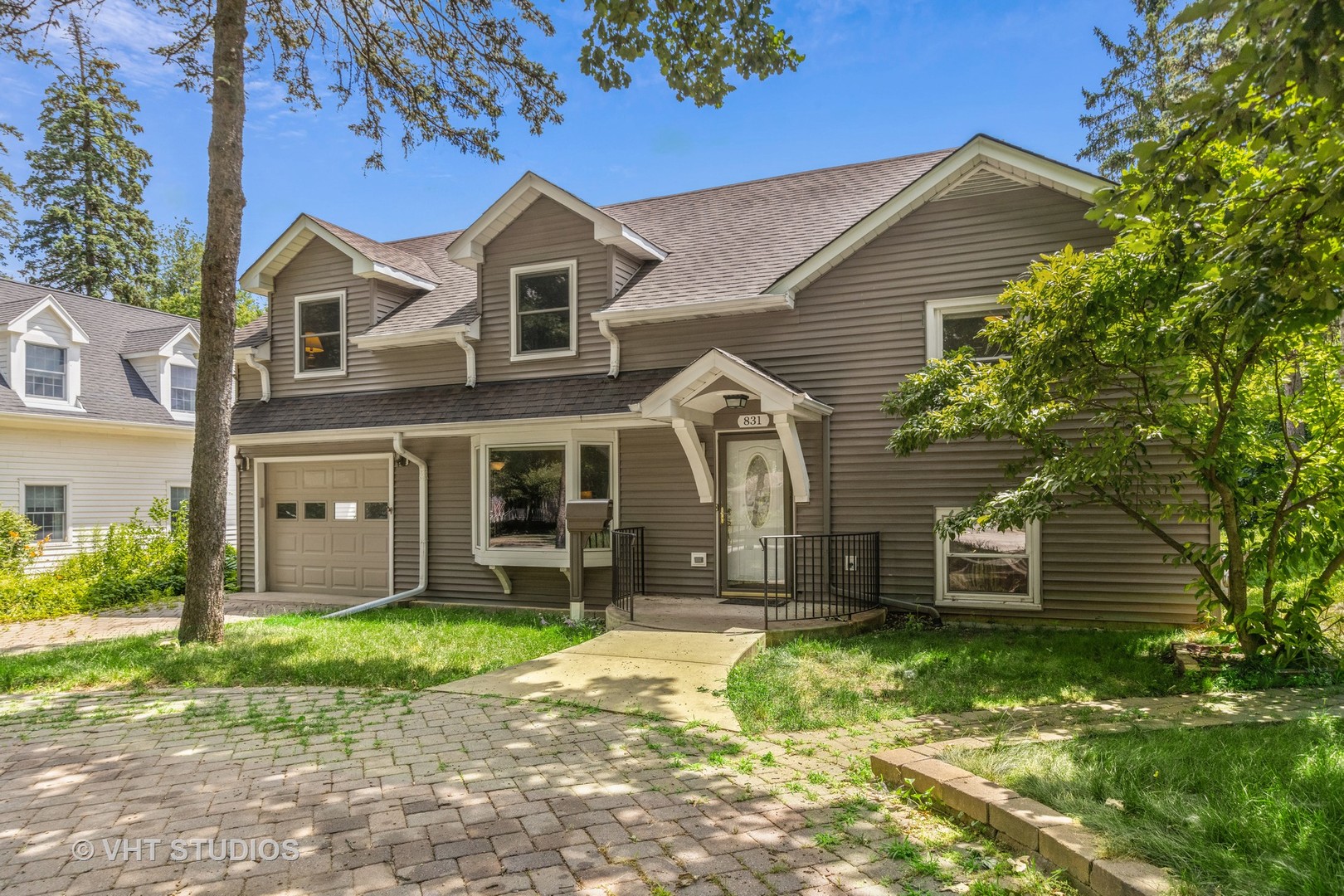 831 Warrenville Road Wheaton, IL 60189 - Photo 1 of 26 a front view of a house with a garden