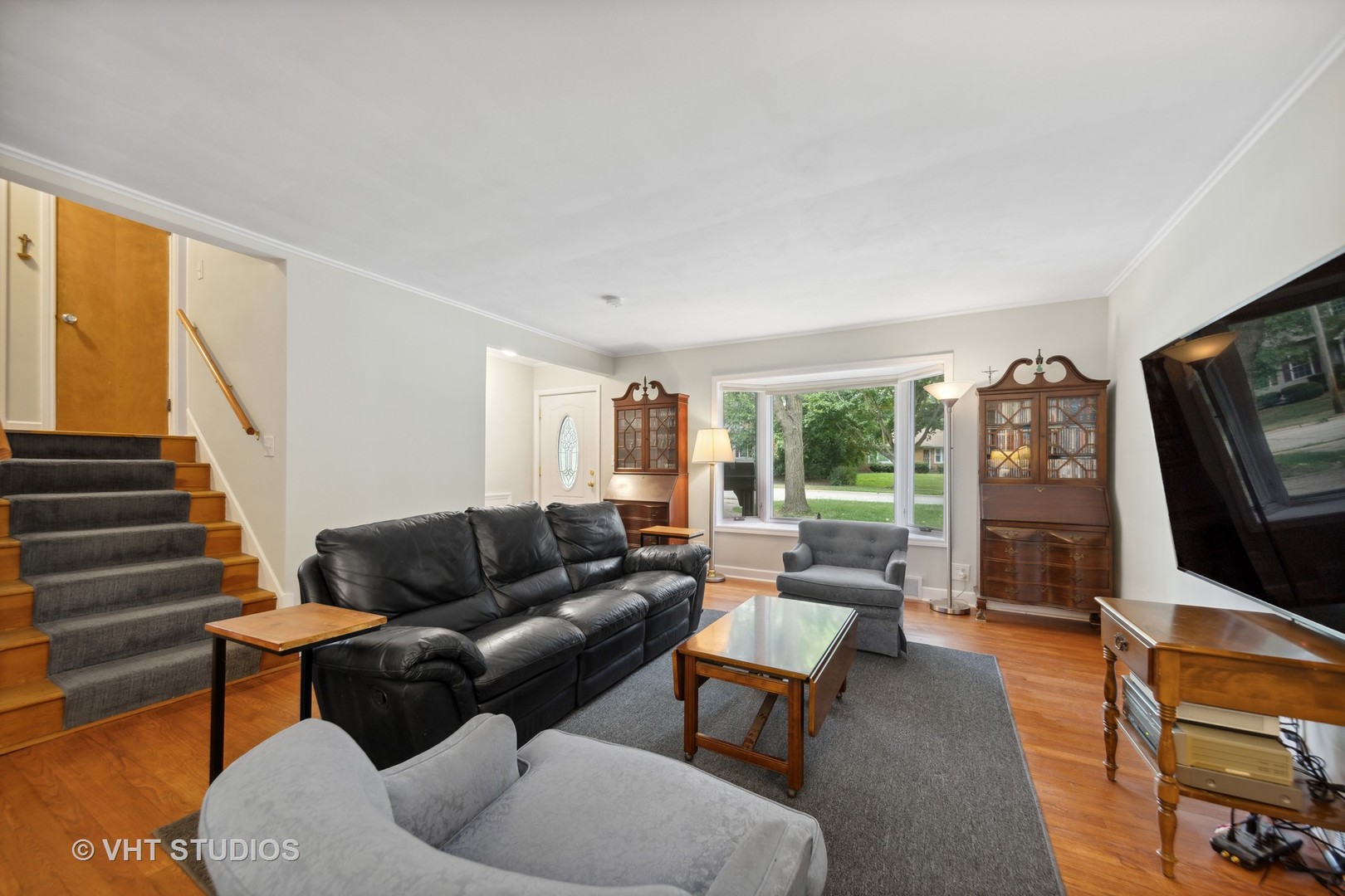 831 Warrenville Road Wheaton, IL 60189 - Photo 2 of 26 a living room with furniture a flat screen tv and a large window