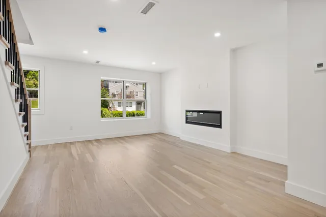 a large kitchen with stainless steel appliances a large counter top a sink a refrigerator and a stove