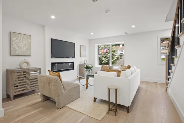 a living room with furniture a flat screen tv and a window