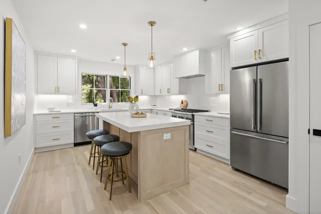 a kitchen with a center island appliances and cabinets