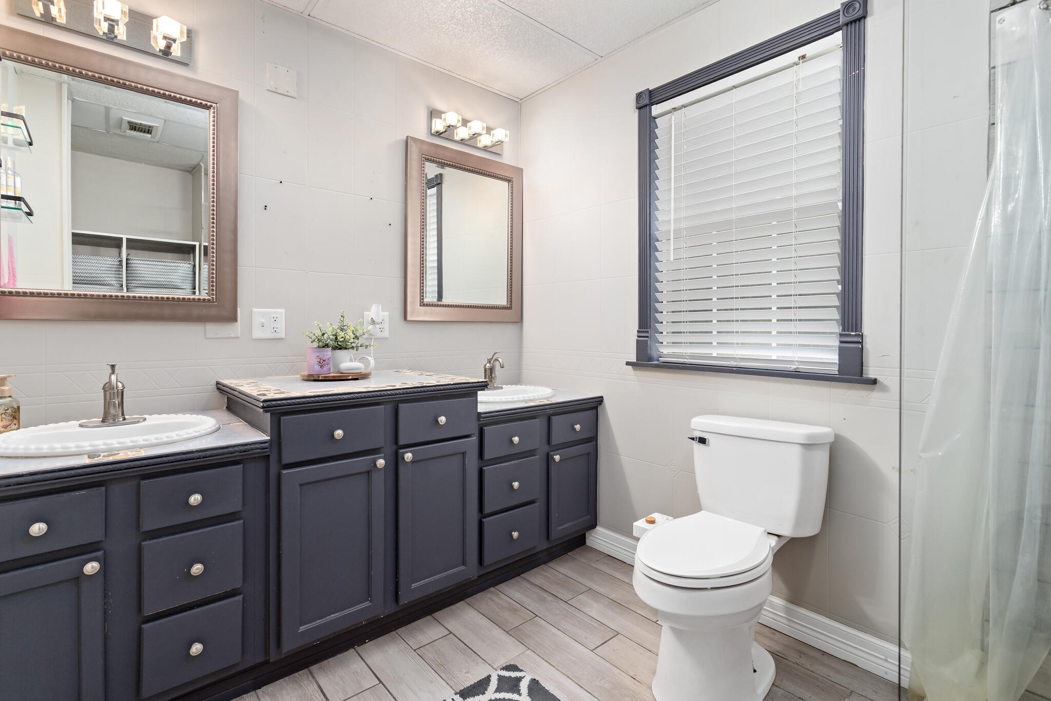7230 Bythewood Road Beaumont, TX 77713 - Photo 23 of 35 a bathroom with a toilet a sink a vanity a mirror and a window