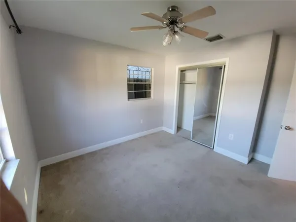 en empty room with windows and fan