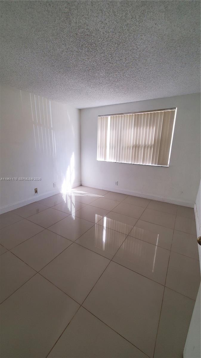 9055 Wiles Road, Unit 103 Coral Springs, FL 33067 - Photo 14 of 19 a view of an empty room with windows