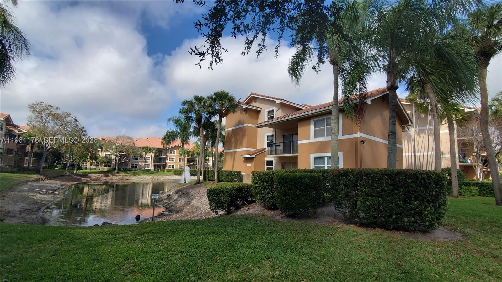 9055 Wiles Road, Unit 103 Coral Springs, FL 33067 - Photo 18 of 19 a front view of a house with a garden and lake view