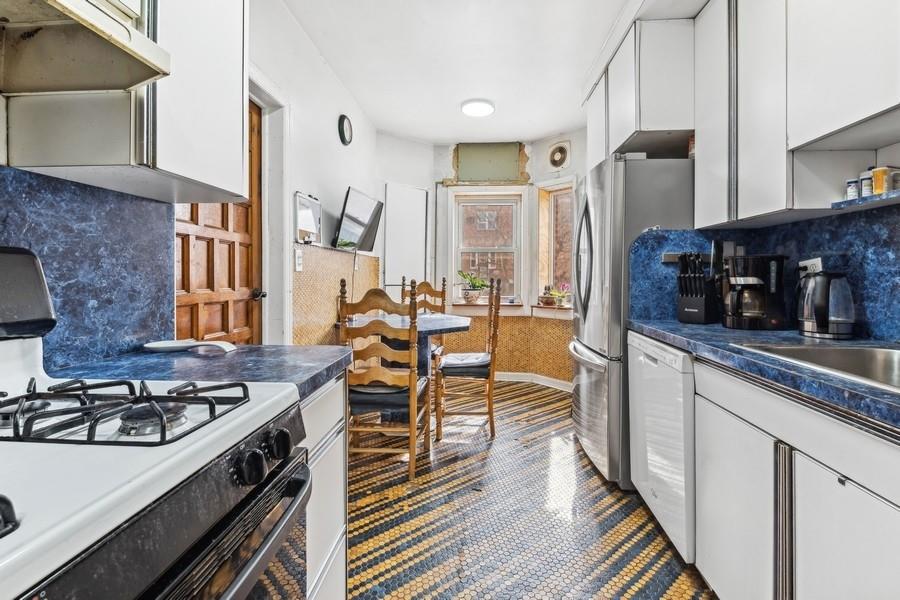 108-28 65th Road Queens, NY 11375 - Photo 6 of 15 a kitchen with stainless steel appliances a stove a sink dishwasher and cabinets with wooden floor