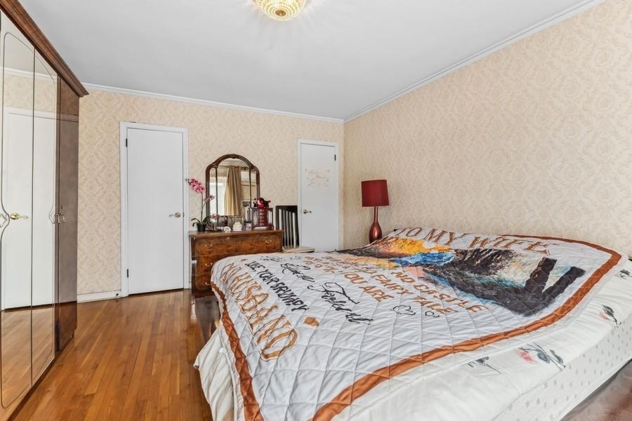 108-28 65th Road Queens, NY 11375 - Photo 10 of 15 a bed sitting in a bedroom next to a window with wooden floor