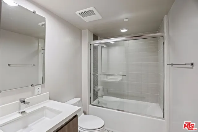 a bathroom with a bathtub shower sink and toilet