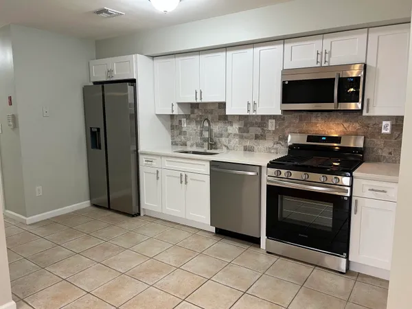 a kitchen with stainless steel appliances granite countertop a stove a microwave and a refrigerator