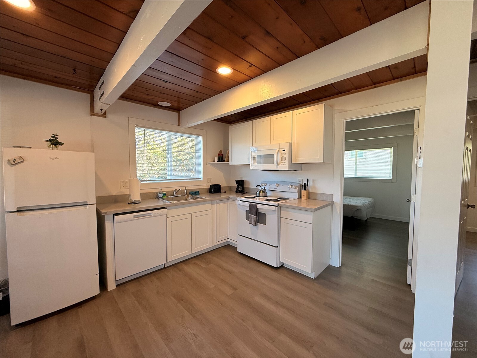 141 Barnacle Street Ocean Shores, WA 98569 - Photo 13 of 27 a kitchen with white cabinets and white appliances