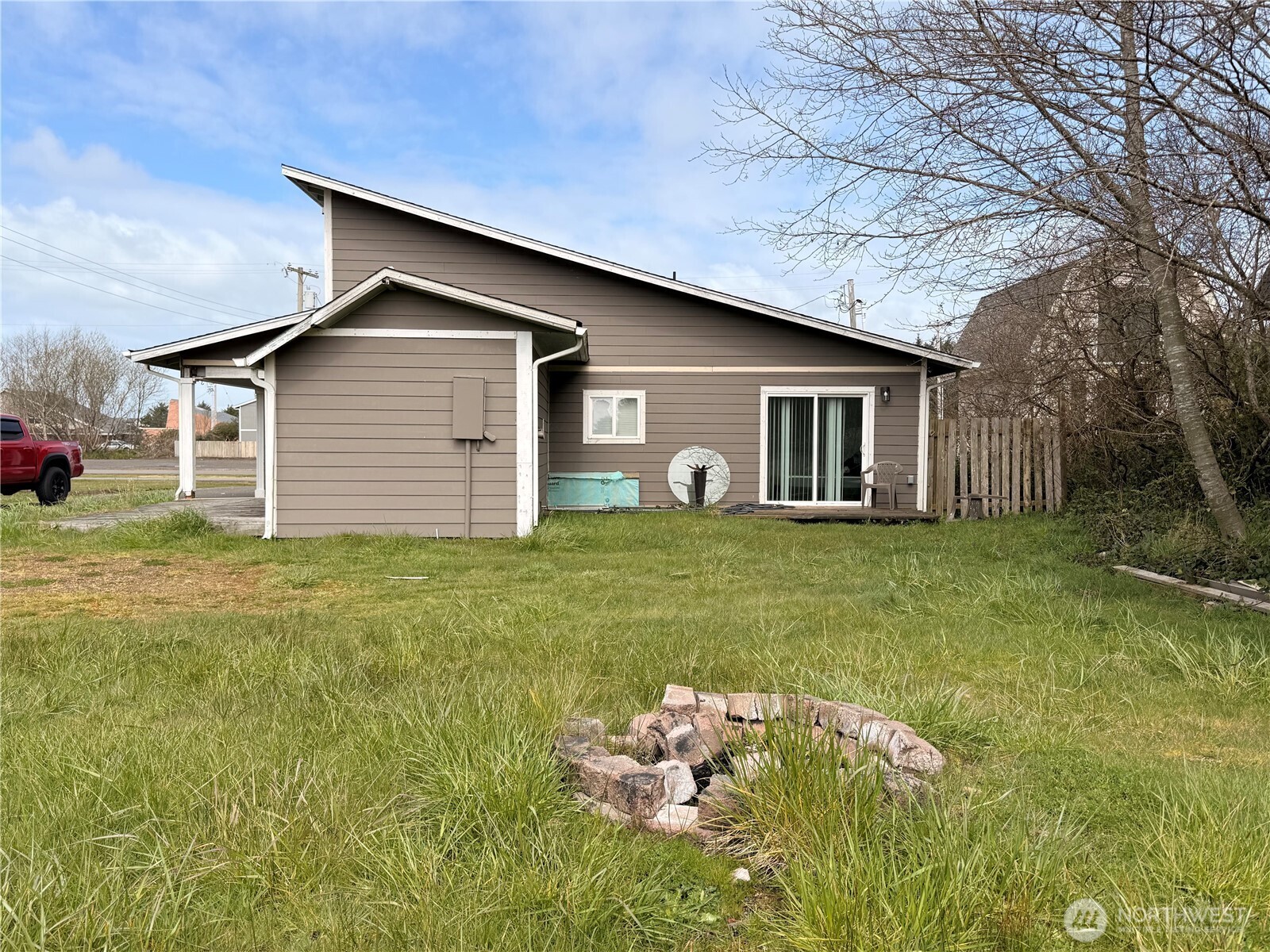 141 Barnacle Street Ocean Shores, WA 98569 - Photo 23 of 27 a front view of house with yard and trees in the background