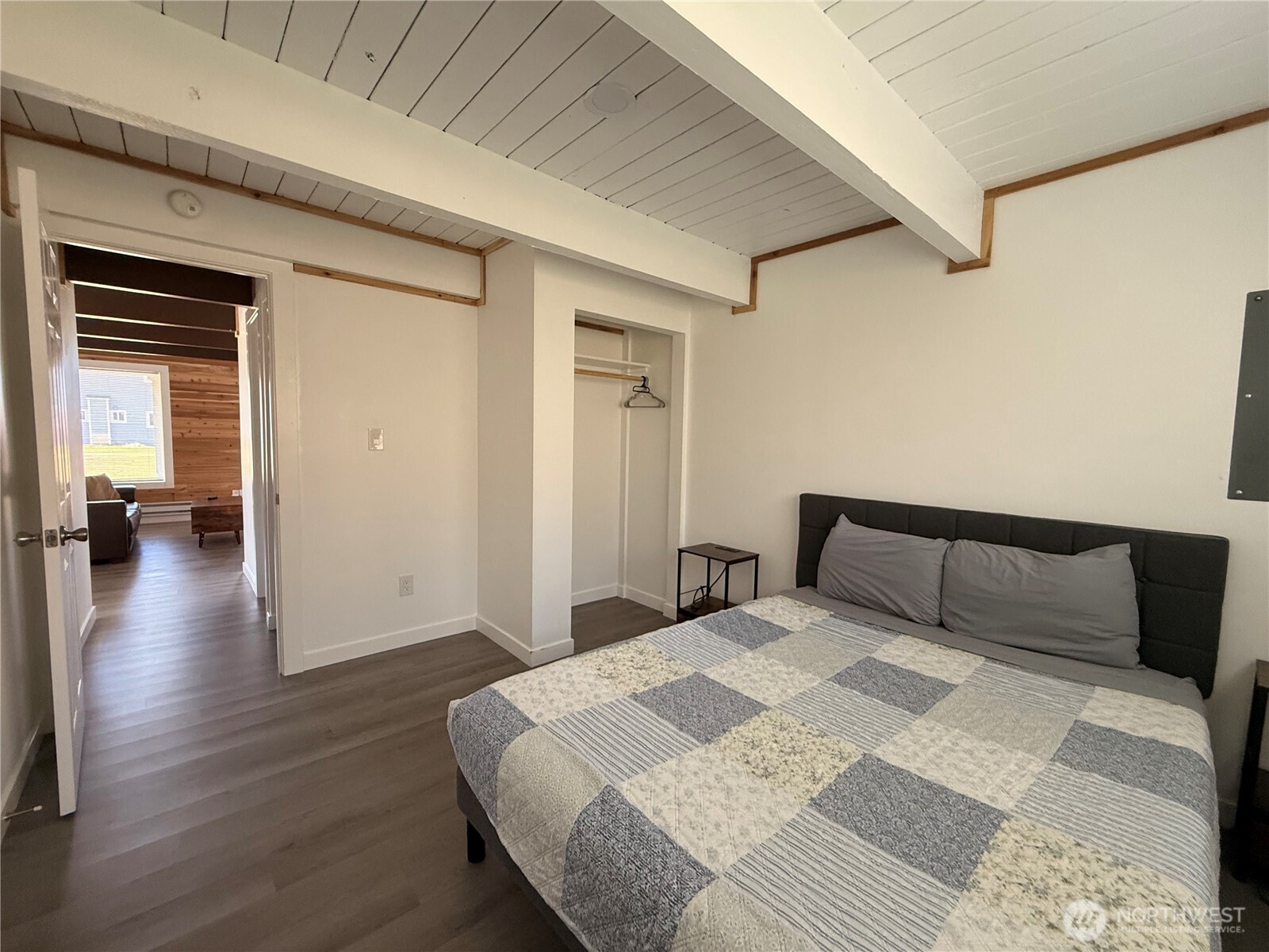 141 Barnacle Street Ocean Shores, WA 98569 - Photo 7 of 27 a bedroom with a bed and wooden floor