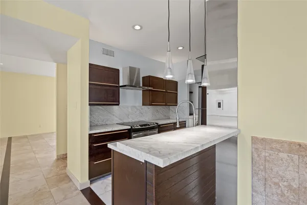 a kitchen with granite countertop a refrigerator and a sink