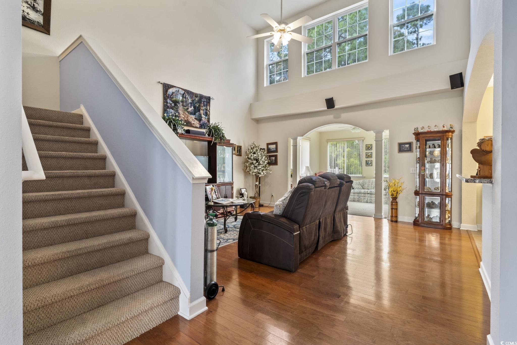 2356 Seneca Ridge Drive Myrtle Beach, SC 29579 - Photo 12 of 39 Living area featuring a high ceiling, hardwood / wood-style flooring, arched walkways, stairway, and ceiling fan