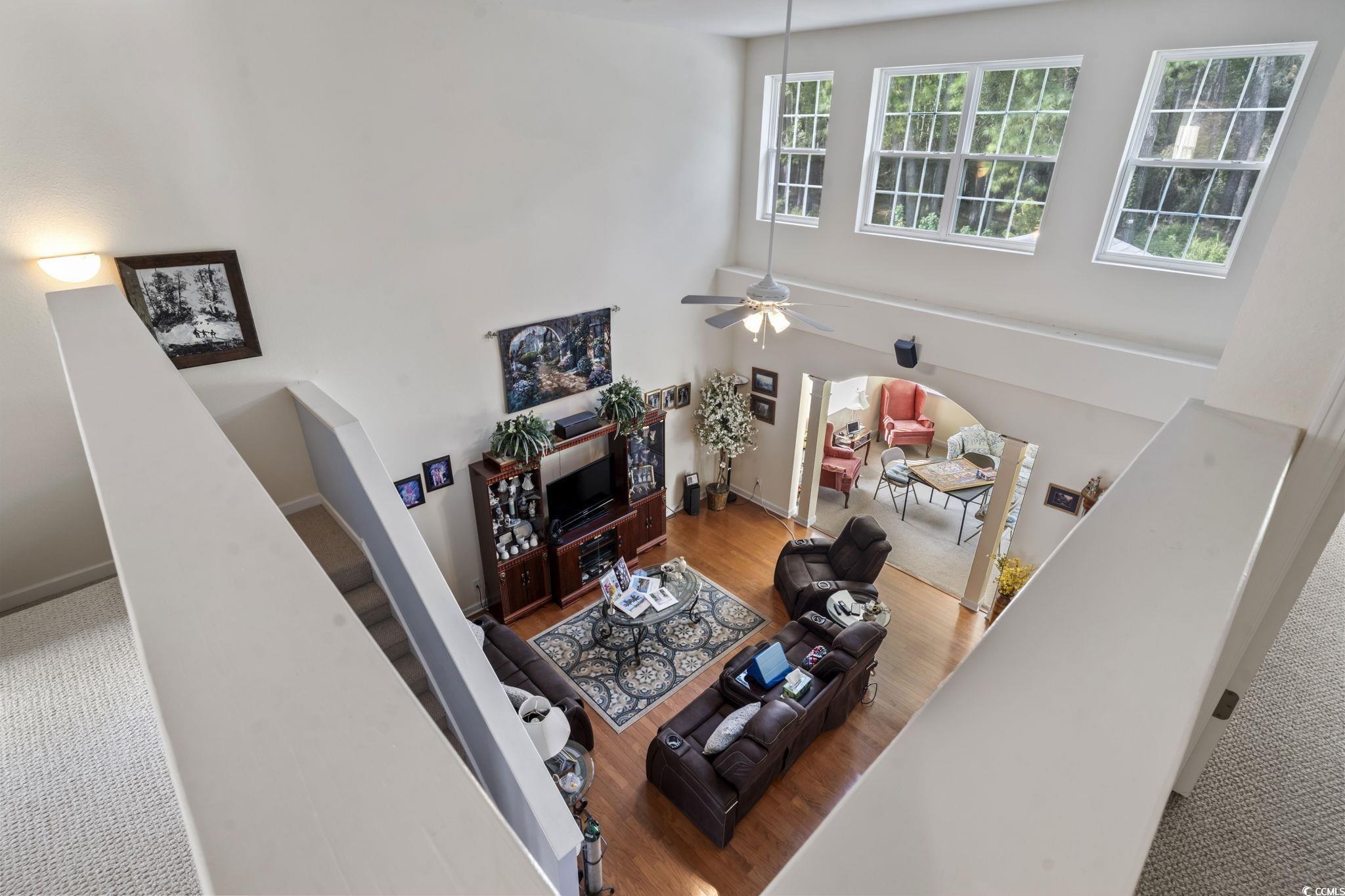 2356 Seneca Ridge Drive Myrtle Beach, SC 29579 - Photo 23 of 39 Carpeted living area with arched walkways, a high ceiling, a ceiling fan, and wood finished floors