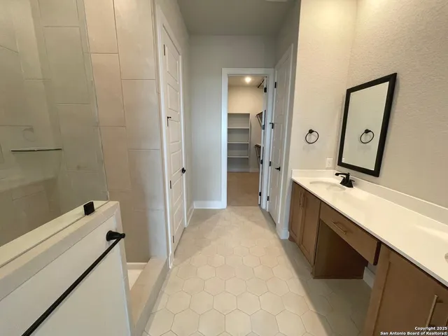 a bathroom with a tub sink and mirror