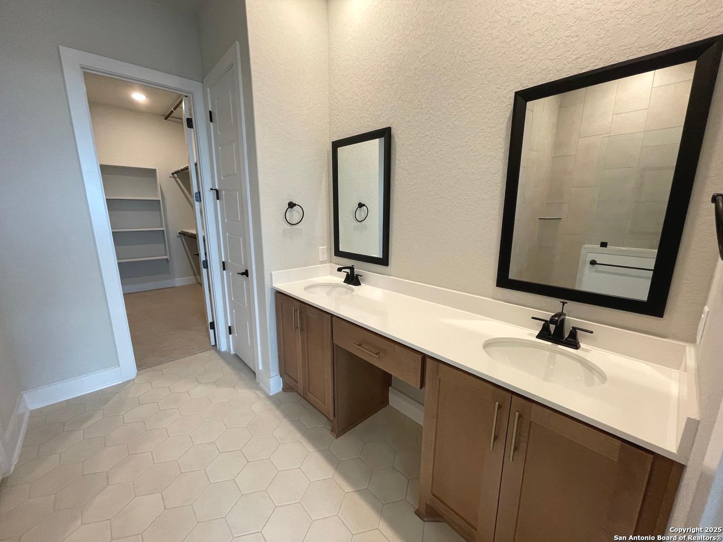 20675 Huebner Road, Unit 525 San Antonio, TX 78258 - Photo 13 of 19 a bathroom with double vanity and a mirror