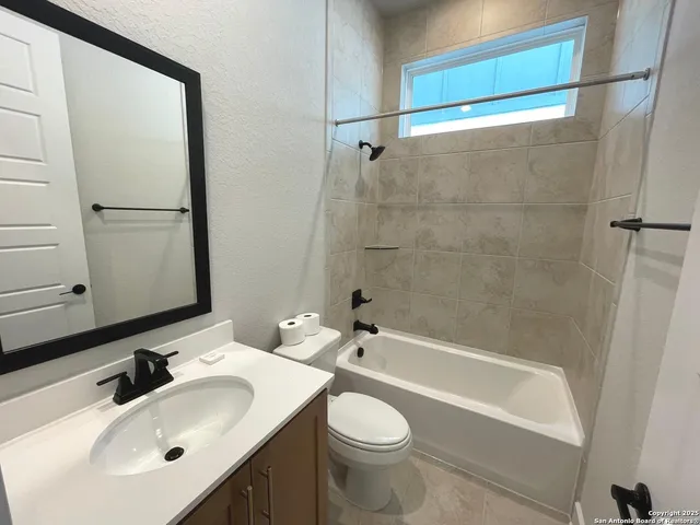 a bathroom with a white bath tub a sink and mirror