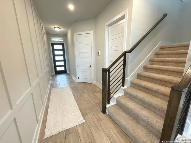 a view of a hallway with wooden floor and entryway