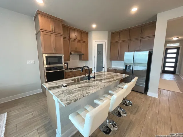 a kitchen with kitchen island a counter top space appliances and cabinets