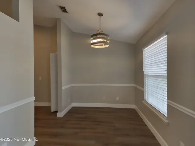 a view of a room with wooden floors and white walls