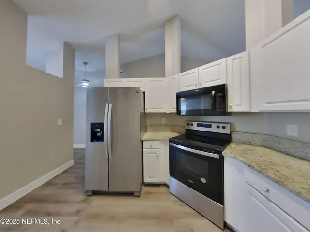 a kitchen with stainless steel appliances granite countertop a refrigerator stove and microwave