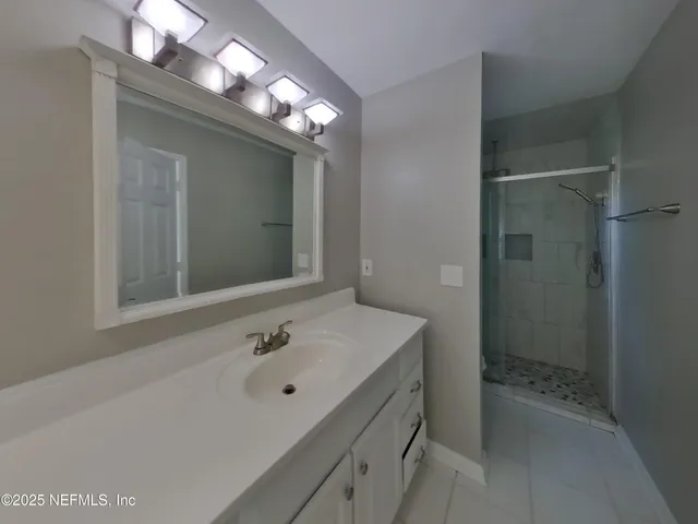 a bathroom with a sink a shower and a mirror