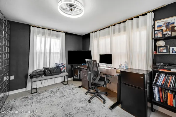 a view of a livingroom with workspace and a window