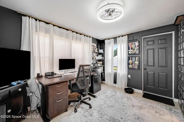 a view of a livingroom with workspace and a window