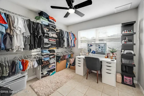 a view of walk in closet with clothes and shoes