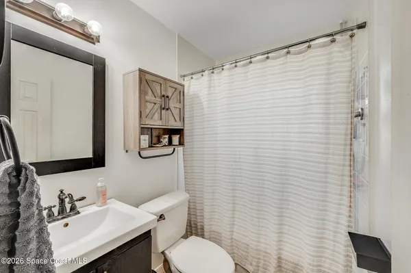 a bathroom with a sink a toilet and shower curtain