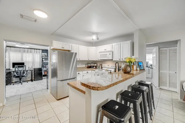 a kitchen with a refrigerator a sink and chairs