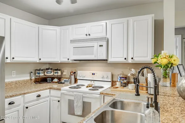 a kitchen with stainless steel appliances granite countertop a sink a stove and cabinets
