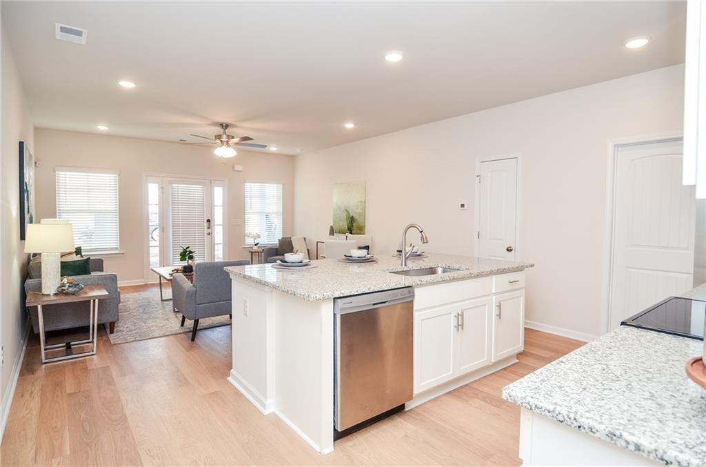 4551 High Rdg Court Sugar Hill, GA 30518 - Photo 17 of 40 a large kitchen with kitchen island a sink a stove a dining table and chairs